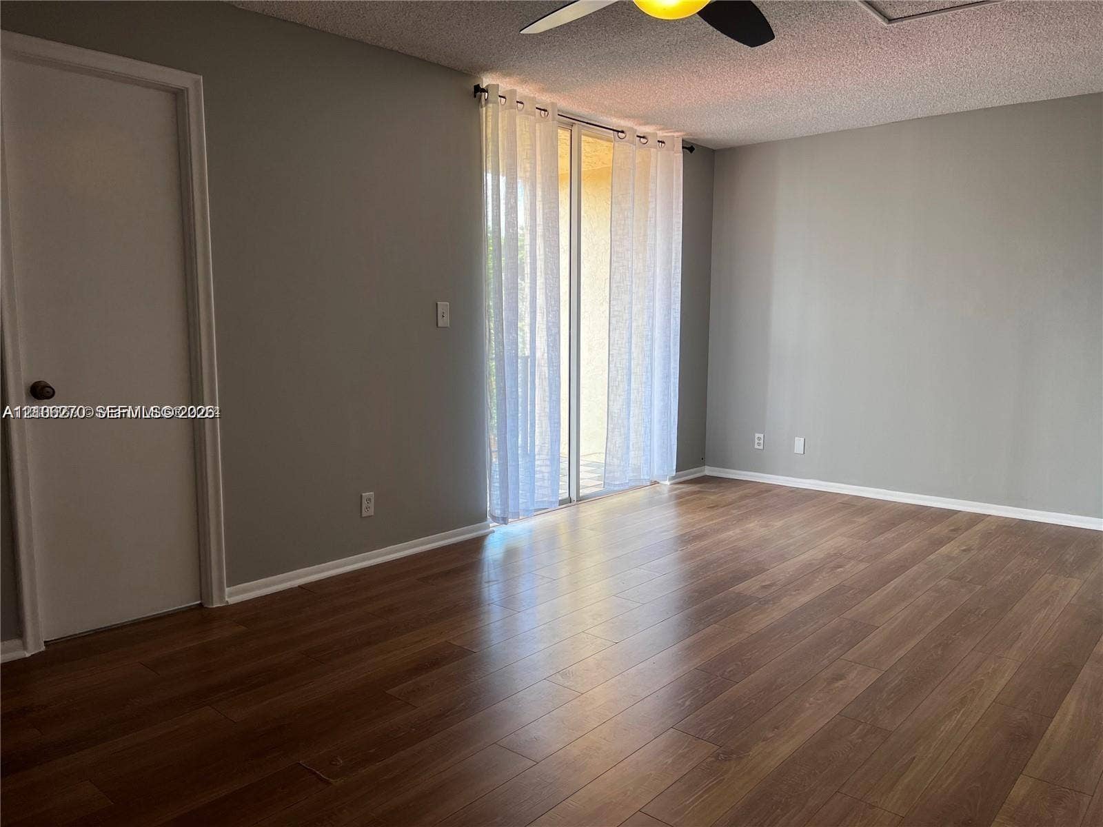 2410 NE 10th Street, #123, Hallandale Beach, Hallandale Beach, FL 33009 Interior space featuring wood-finish flooring, sliding glass door, and a ceiling fan with integrated lighting
