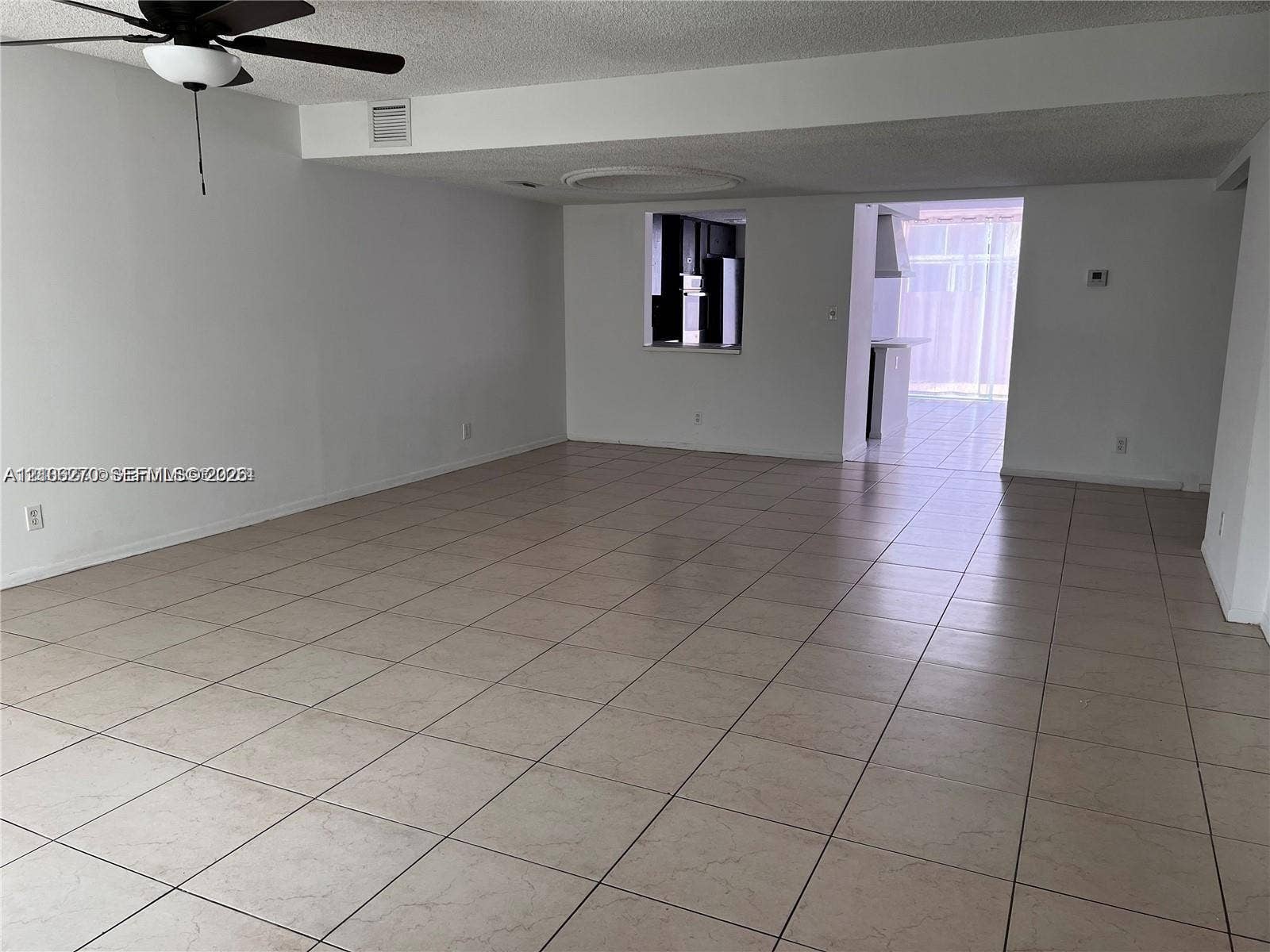 2410 NE 10th Street, #123, Hallandale Beach, Hallandale Beach, FL 33009 Open floor plan featuring neutral ceramic tile flooring, ceiling fan with integrated lighting, and a pass-through window