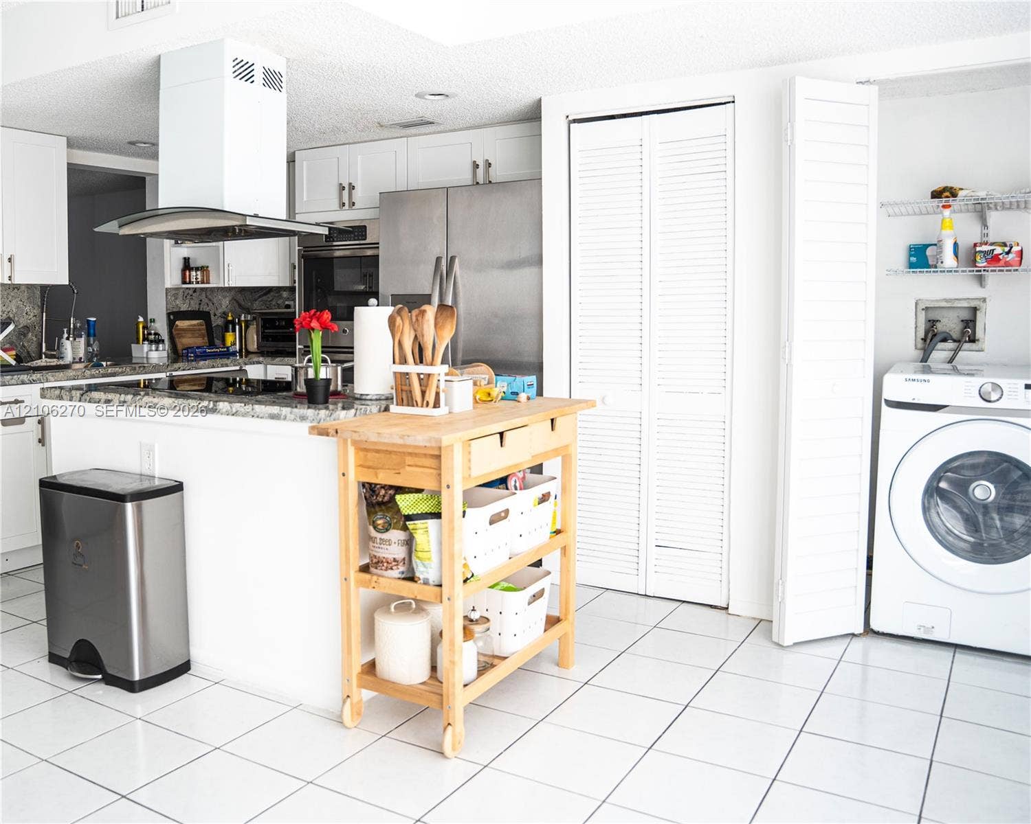 2410 NE 10th Street, #123, Hallandale Beach, Hallandale Beach, FL 33009 Kitchen featuring white cabinetry, stone countertops, stainless steel appliances, a chimney-style range hood, and tile flooring
