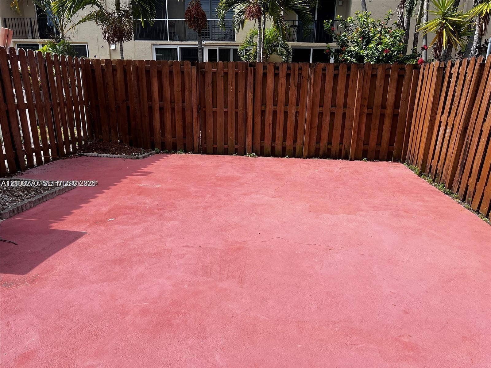 2410 NE 10th Street, #123, Hallandale Beach, Hallandale Beach, FL 33009 Private patio featuring a poured concrete surface enclosed by tall wood-slat fencing