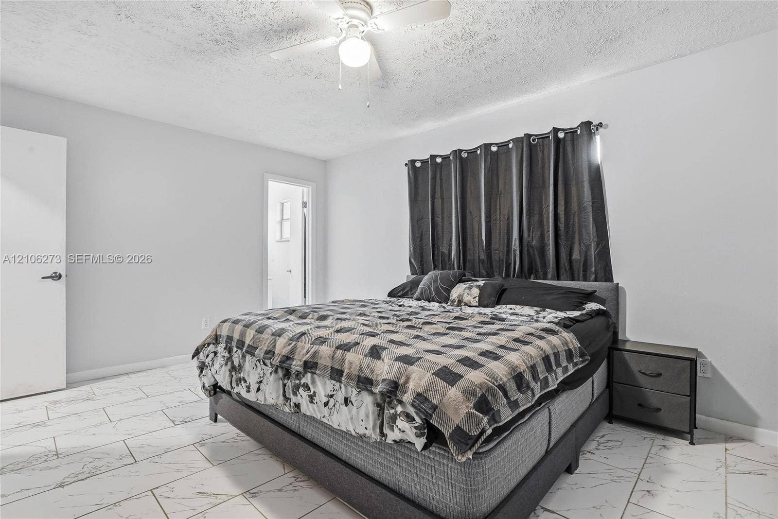 5310 Seagrape Drive, Fort Pierce, FL 34982 Neutral-toned room featuring large-format tile flooring, a multi-blade ceiling fan with integrated lighting, and a solid-core interior door