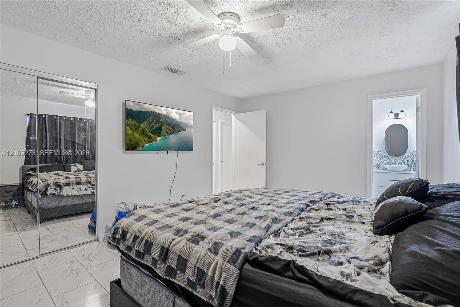 5310 Seagrape Drive, Fort Pierce, FL 34982 Bedroom featuring white tile flooring, ceiling fan, and mirrored sliding closet doors