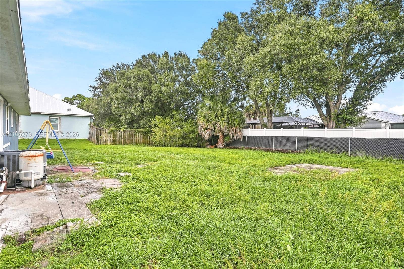 5310 Seagrape Drive, Fort Pierce, FL 34982 Backyard featuring a grass lawn, perimeter vinyl fencing, and mature trees