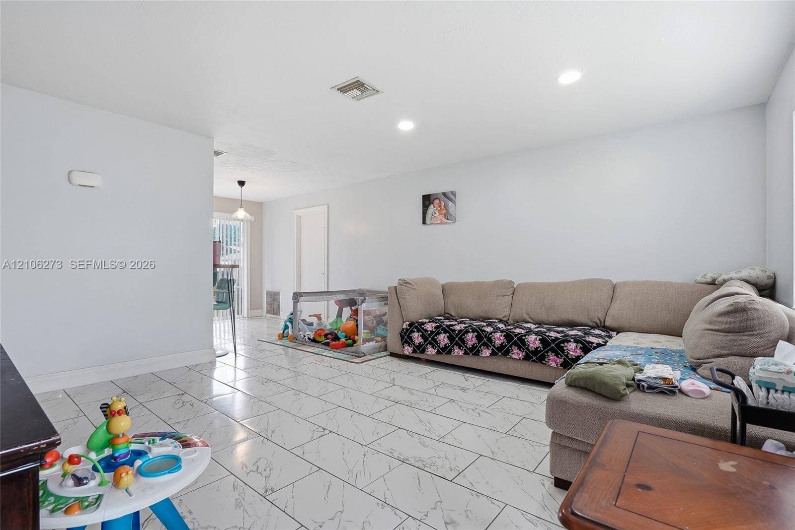 5310 Seagrape Drive, Fort Pierce, FL 34982 Open-concept living space featuring large-format rectified tile flooring with a marble-style finish and recessed ceiling lighting