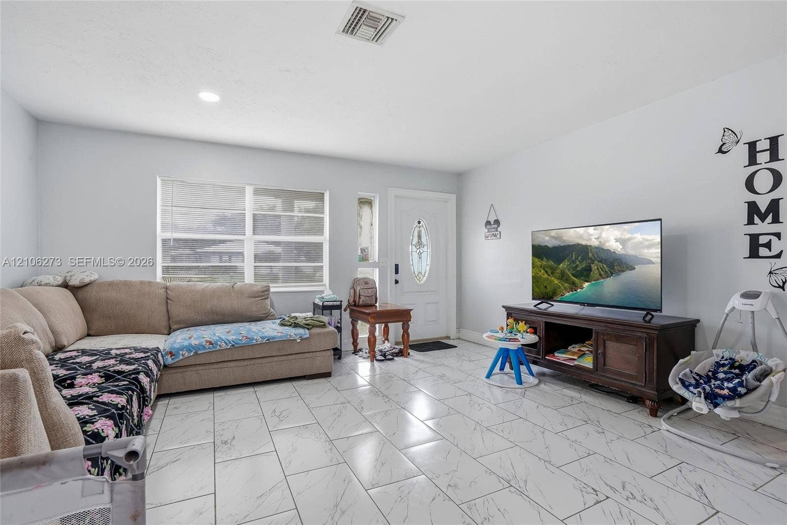 5310 Seagrape Drive, Fort Pierce, FL 34982 Living area featuring large-format tile flooring, recessed lighting, and an exterior door with decorative glass inlay