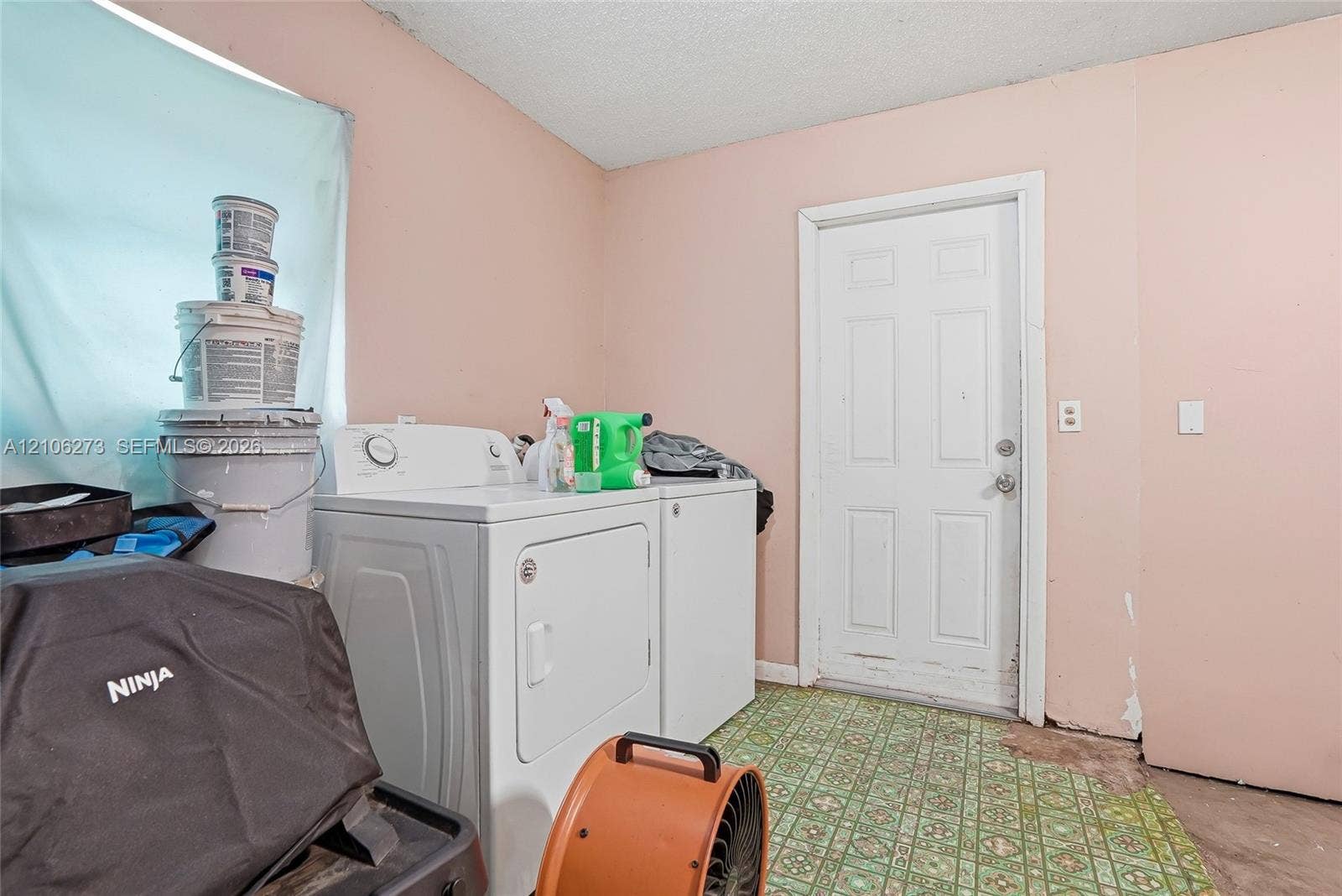 5310 Seagrape Drive, Fort Pierce, FL 34982 Utility area featuring a six-panel exterior door and patterned resilient flooring