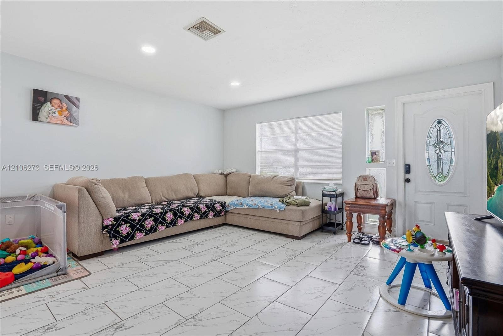 5310 Seagrape Drive, Fort Pierce, FL 34982 Living area featuring large-format tile flooring with marble-style veining, recessed lighting, and a front entry door with a decorative oval glass insert