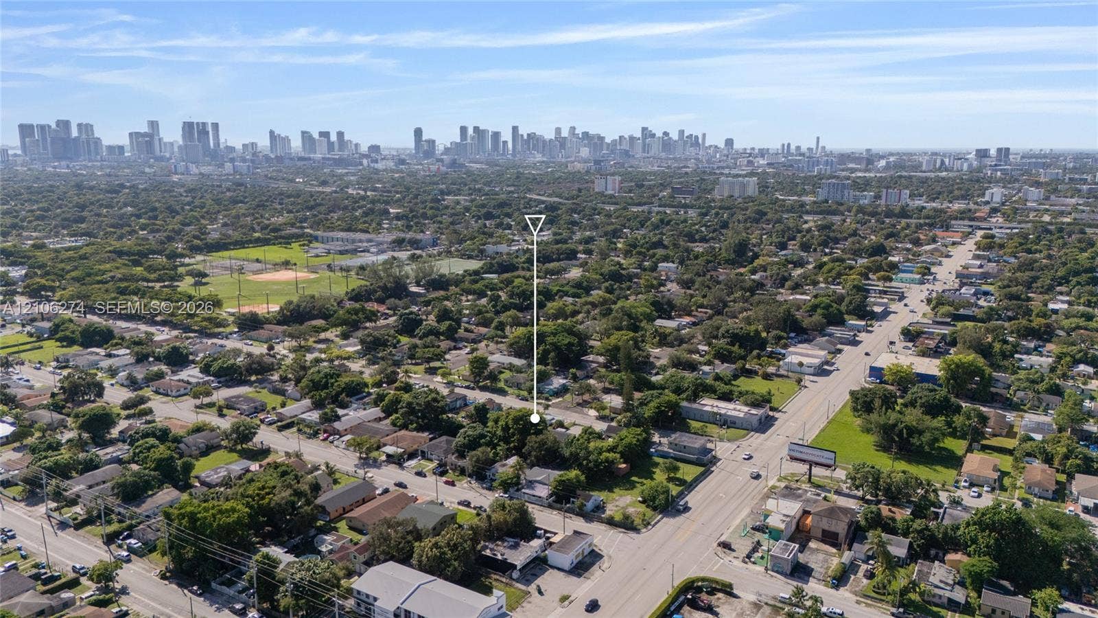 1601 NW 50th Street, Miami, FL 33142 Aerial perspective featuring a residential lot with mature trees, situated within proximity to urban skyline infrastructure and local park grounds