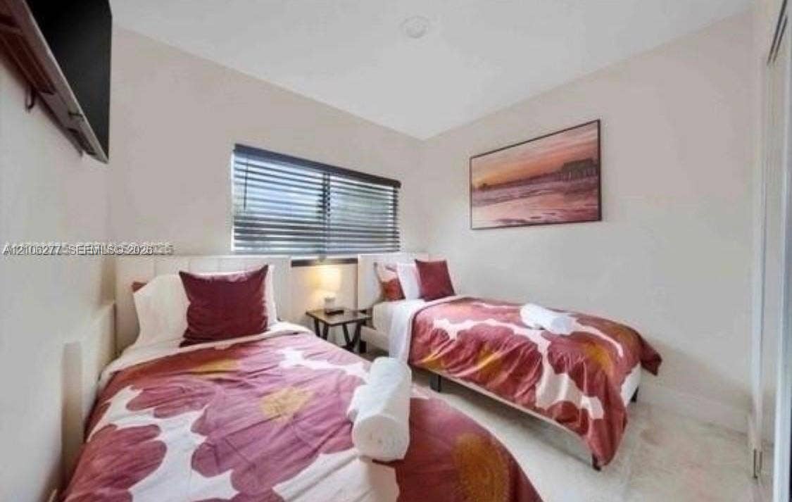 Room featuring polished stone flooring, neutral wall tones, and window blinds