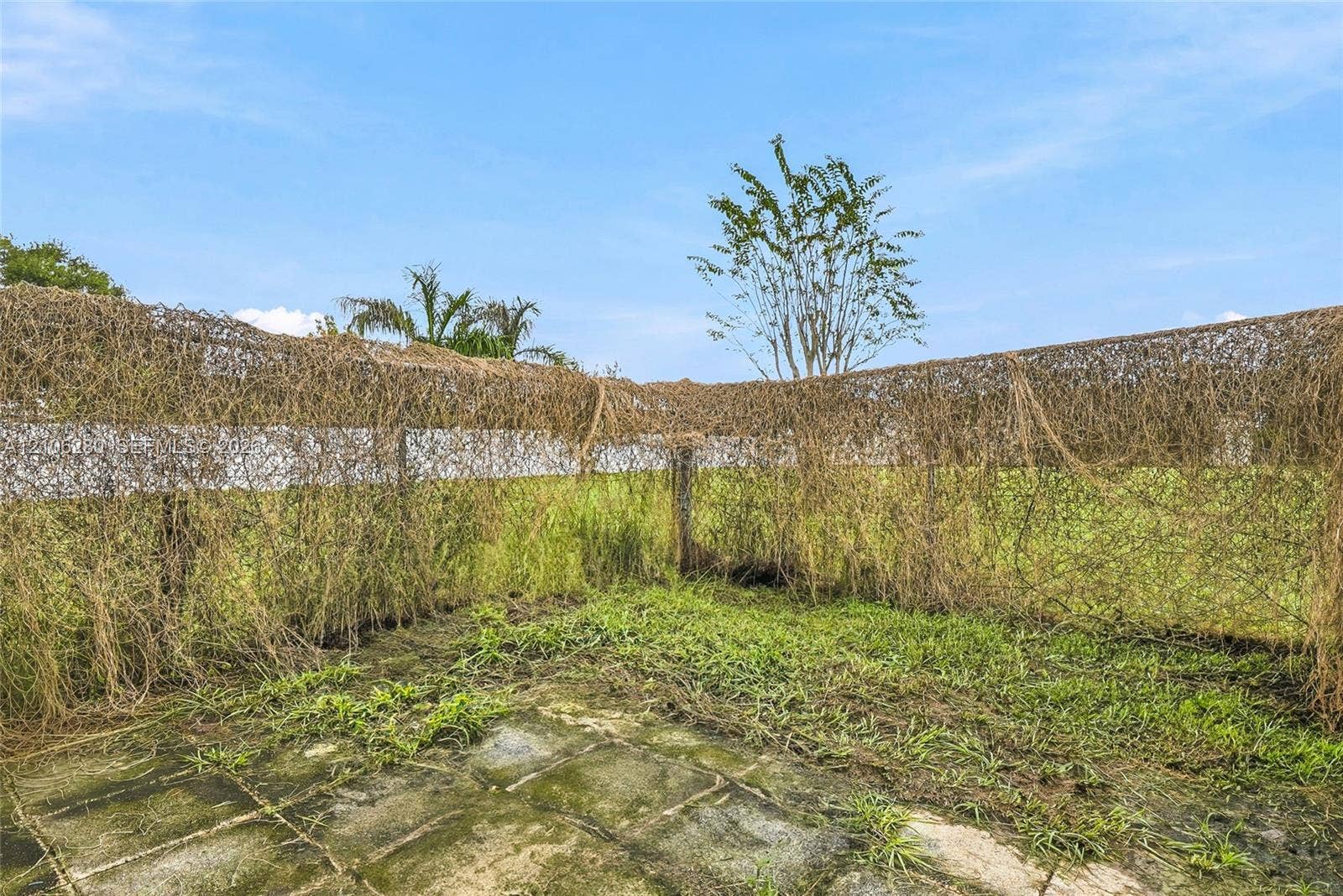 2017 SE Ancora Court, Port St Lucie, FL 34952 Outdoor space featuring a paved stone patio and a wire mesh perimeter fence