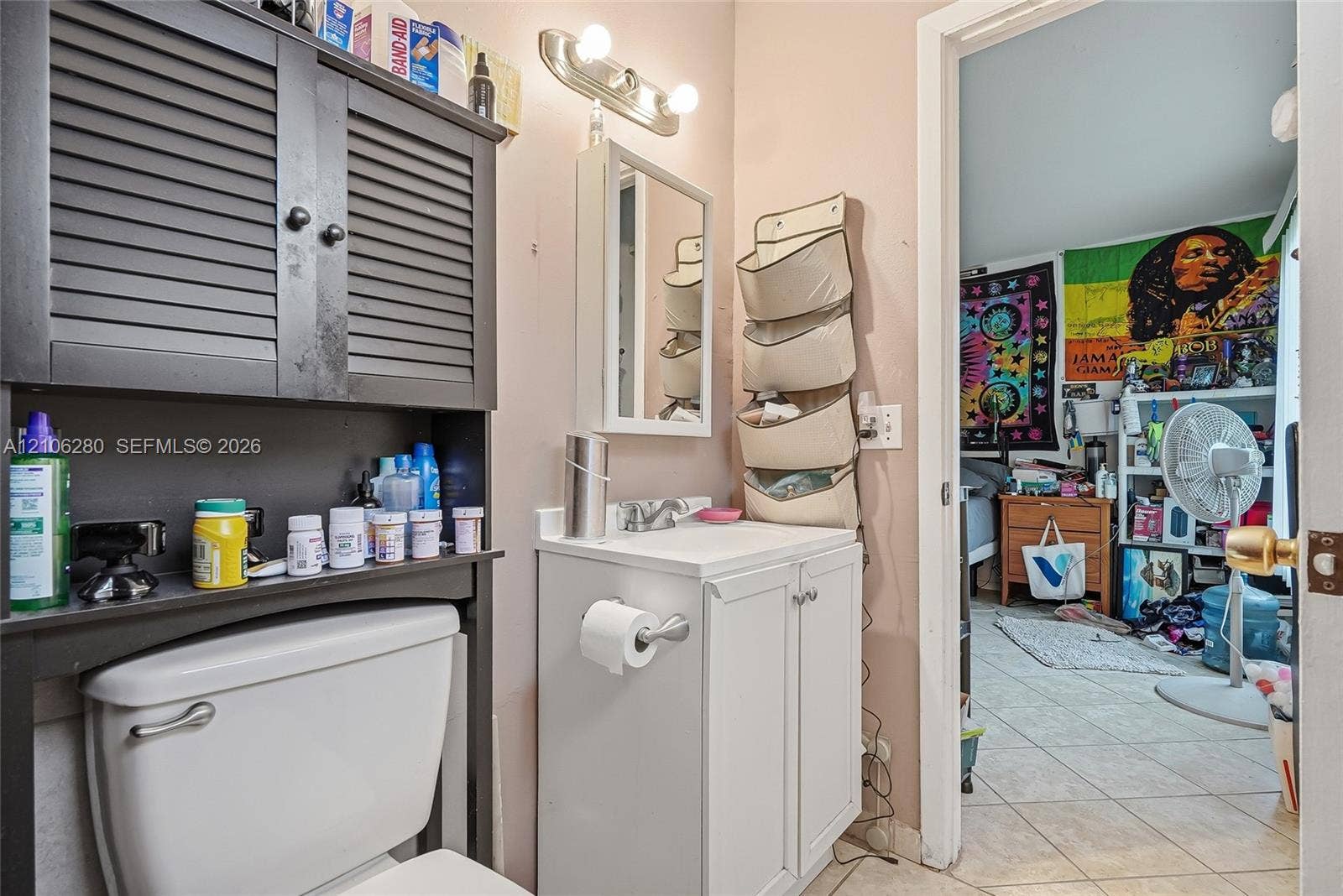 2017 SE Ancora Court, Port St Lucie, FL 34952 White vanity cabinet with an integrated rectangular sink, chrome faucet, wall-mounted medicine cabinet, and a multi-bulb light fixture