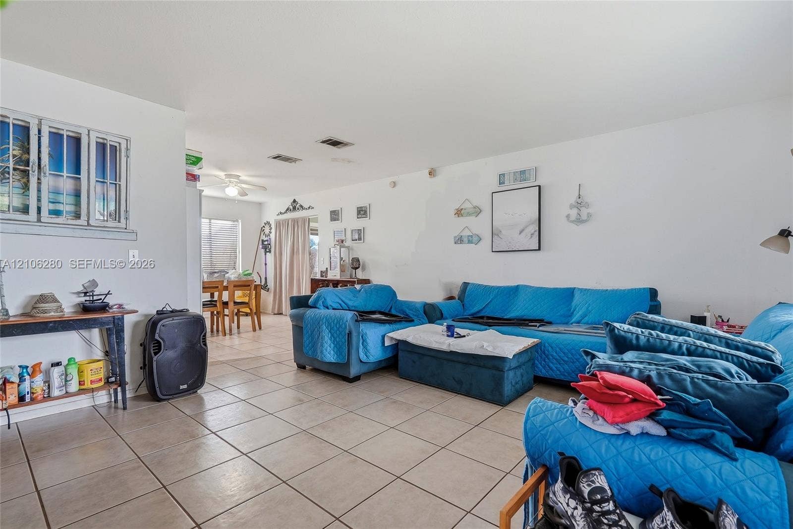 2017 SE Ancora Court, Port St Lucie, FL 34952 Open-concept living space featuring large-format ceramic tile flooring, neutral walls, recessed ceiling lighting, and a multi-pane decorative window accent