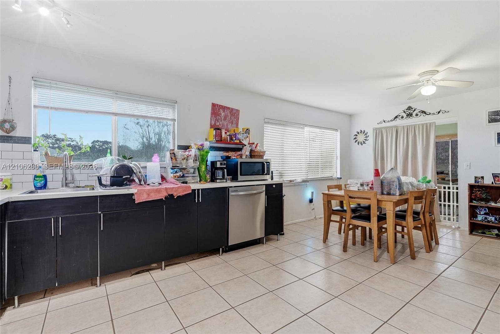 2017 SE Ancora Court, Port St Lucie, FL 34952 Kitchen featuring flat-panel cabinetry, stainless steel dishwasher, white subway tile backsplash, and tile flooring