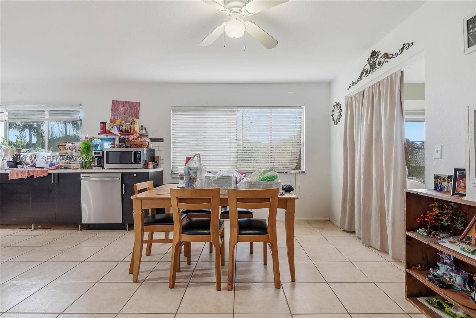 2017 SE Ancora Court, Port St Lucie, FL 34952 Kitchen featuring dark cabinetry, stainless steel dishwasher, tile flooring, and a ceiling fan