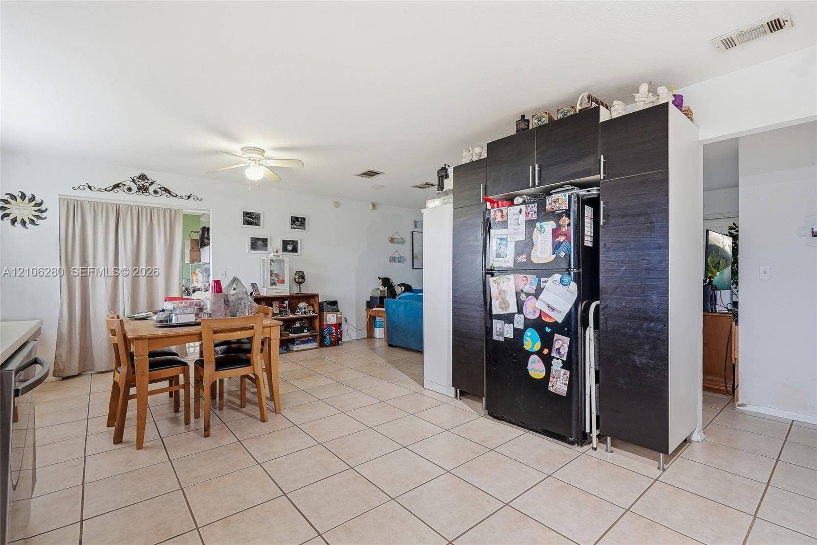 2017 SE Ancora Court, Port St Lucie, FL 34952 Open-concept area featuring ceramic tile flooring, dark wood-finish cabinetry, and a ceiling-mounted light fixture