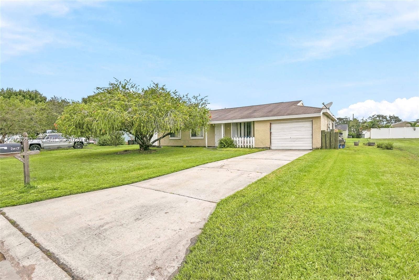 2017 SE Ancora Court, Port St Lucie, FL 34952 Single-story exterior featuring light-toned masonry, an attached one-car garage, and a concrete driveway situated on a spacious lawn