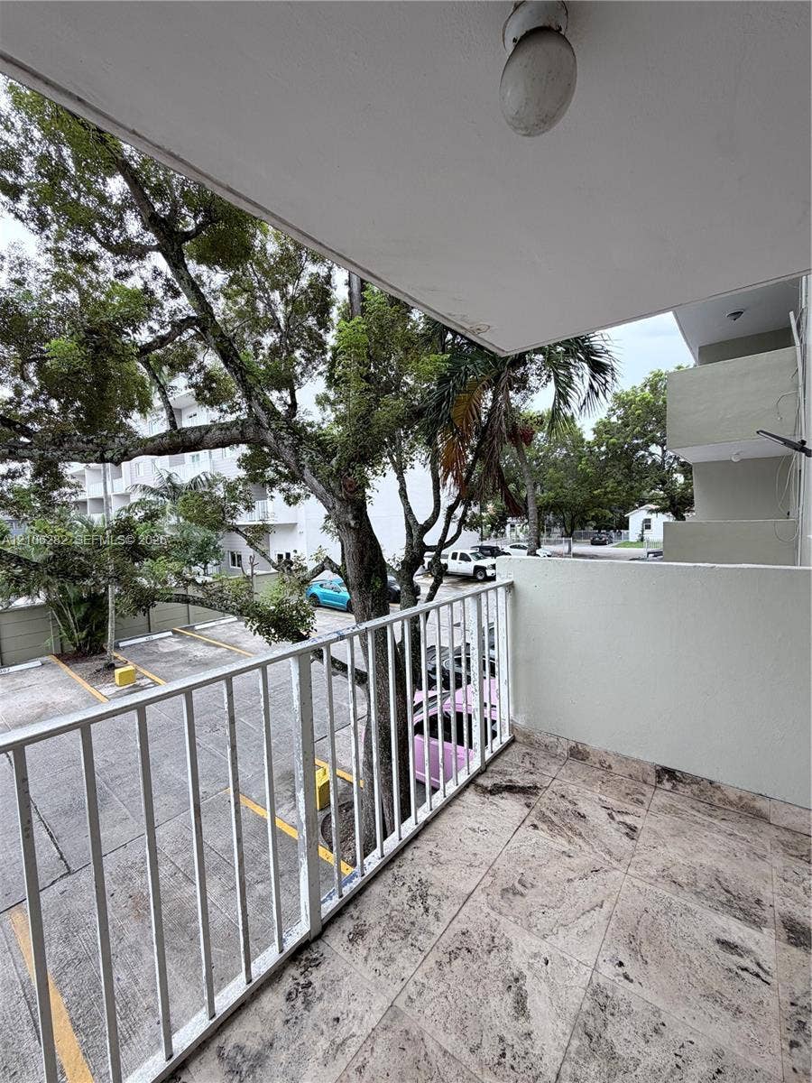 665 NE 83rd Terrace, #210, Miami, Miami, FL 33138 Covered balcony featuring stone-finish flooring, a white metal railing, and an integrated ceiling light fixture