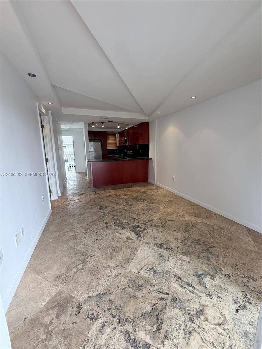 665 NE 83rd Terrace, #210, Miami, Miami, FL 33138 Open-concept area featuring stone tile flooring, custom architectural ceiling design, recessed lighting, and a dark wood-finish kitchen cabinetry island
