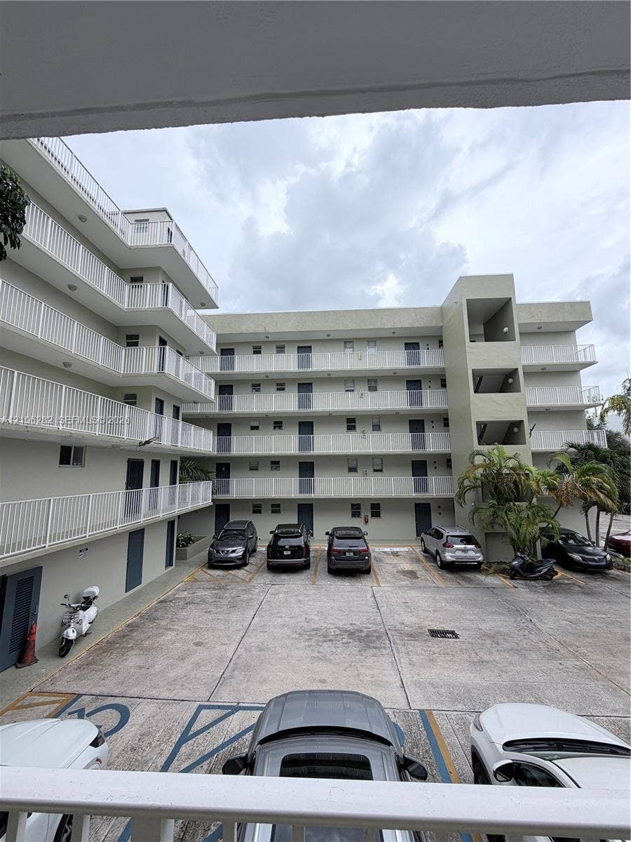 665 NE 83rd Terrace, #210, Miami, Miami, FL 33138 Multi-story exterior featuring concrete construction, white balcony railings, and paved surface parking