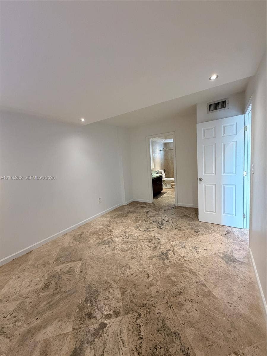 665 NE 83rd Terrace, #210, Miami, Miami, FL 33138 Stone tile flooring featuring a natural texture, recessed ceiling lighting, and a multi-panel interior door