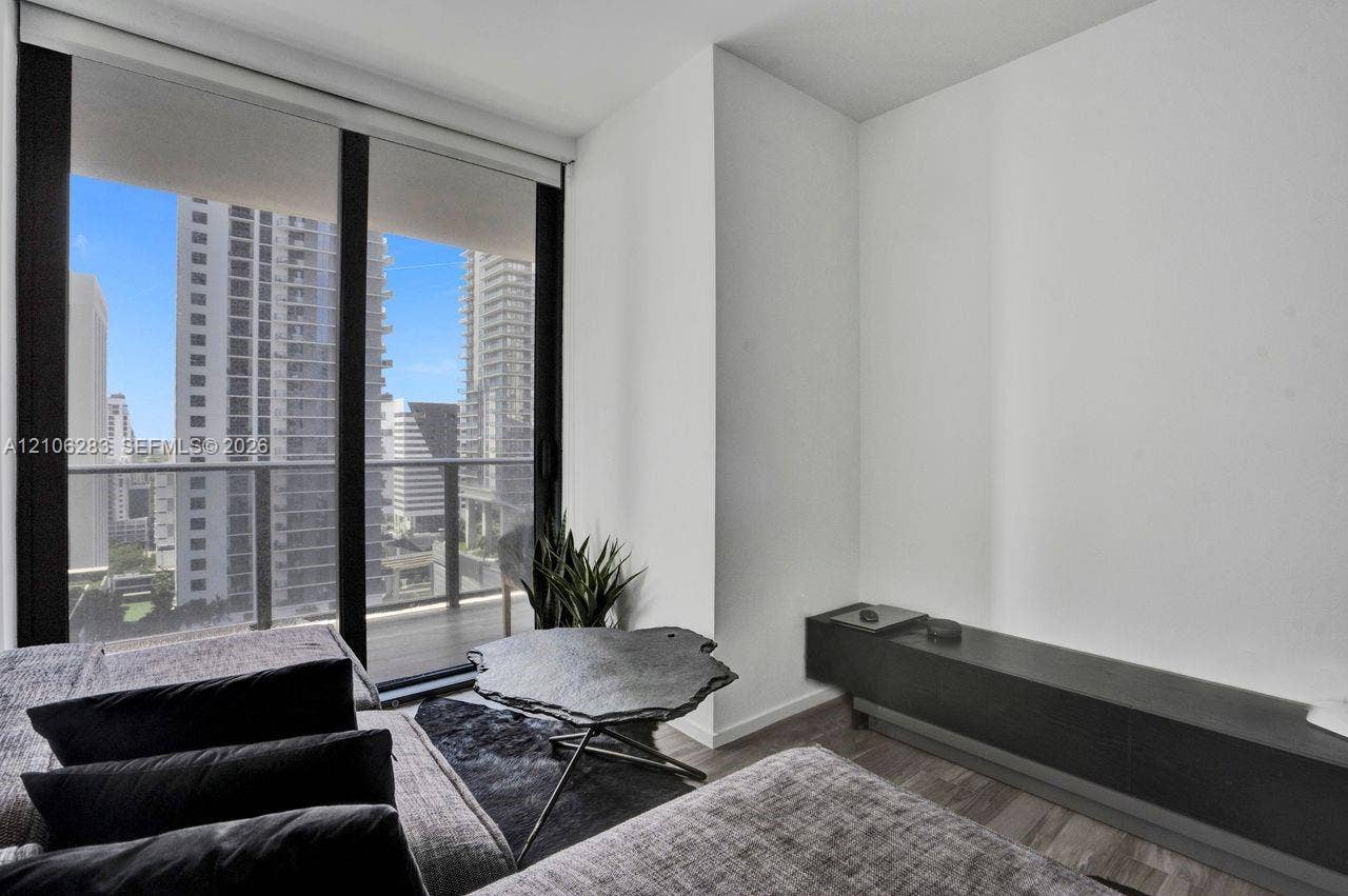 801 S Miami Avenue, #1801, Miami, FL 33130 Floor-to-ceiling glass sliding doors, private balcony with metal railing, and wood-finish flooring