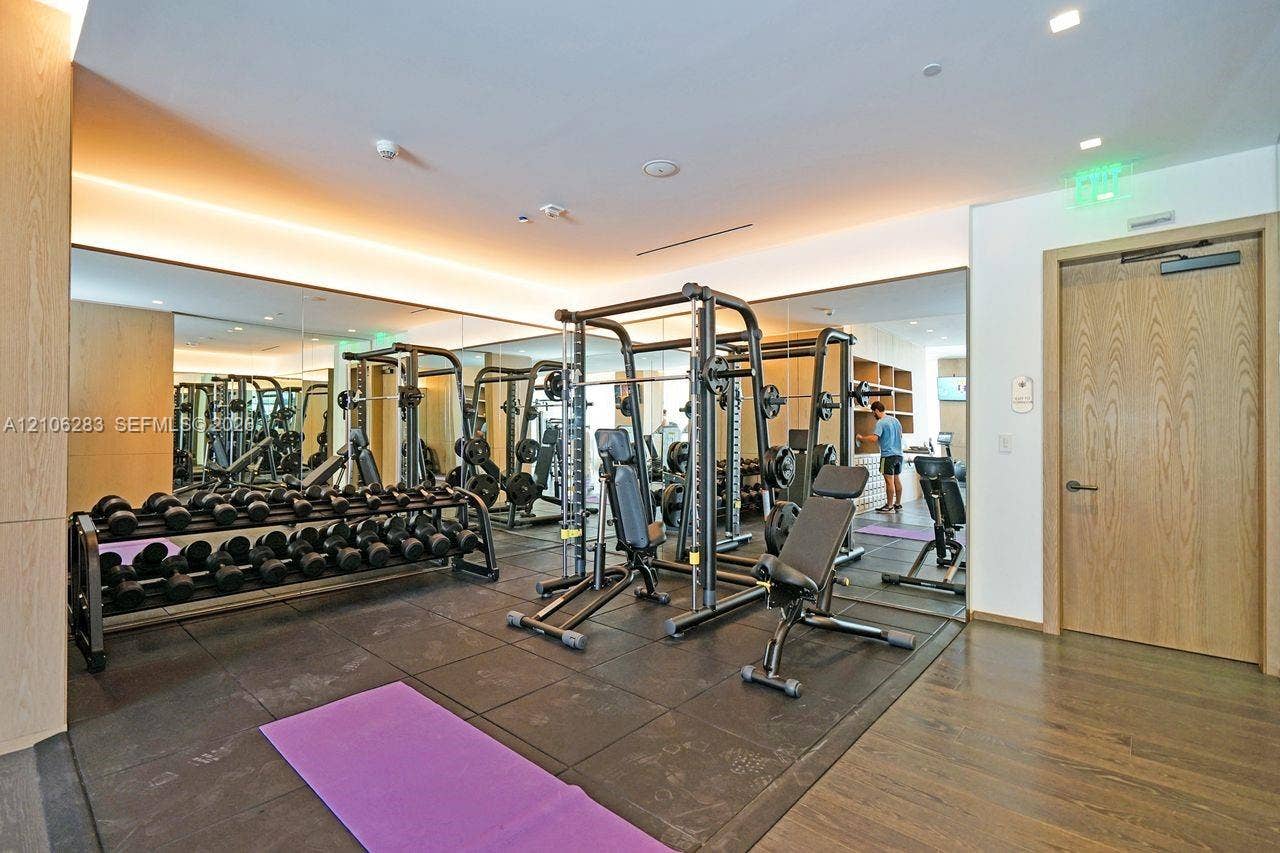 801 S Miami Avenue, #1801, Miami, FL 33130 Fitness center featuring full-wall mirrors, recessed lighting, wood-finish wall paneling, and rubberized flooring