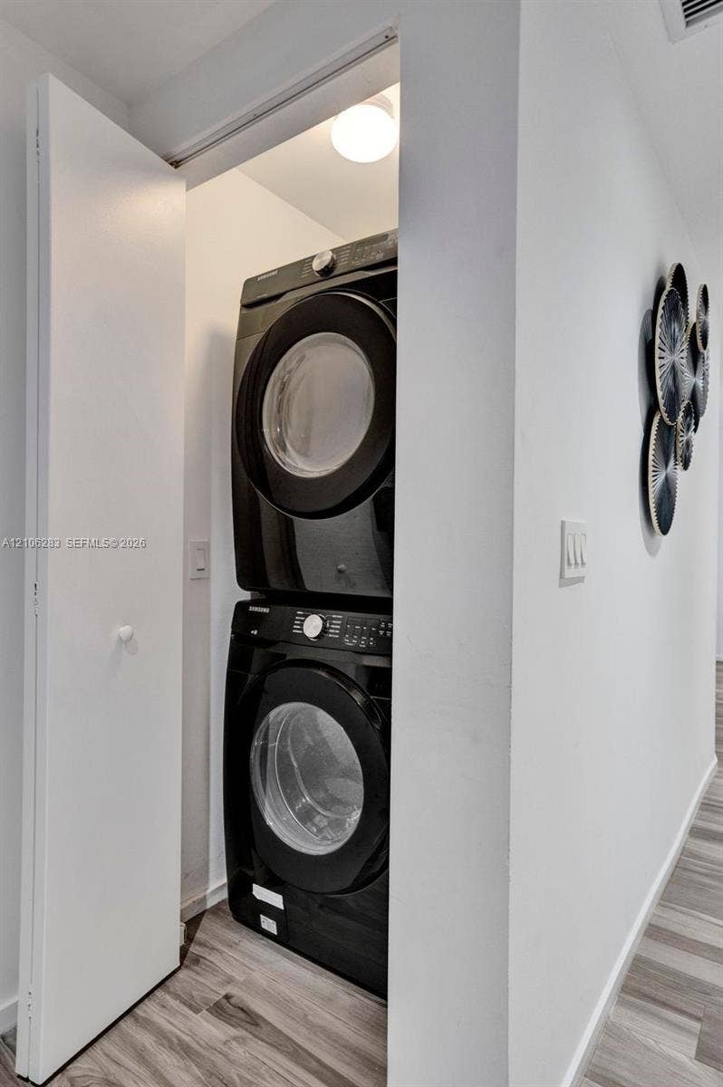 801 S Miami Avenue, #1801, Miami, FL 33130 Laundry closet featuring stackable appliances and wood-finish flooring