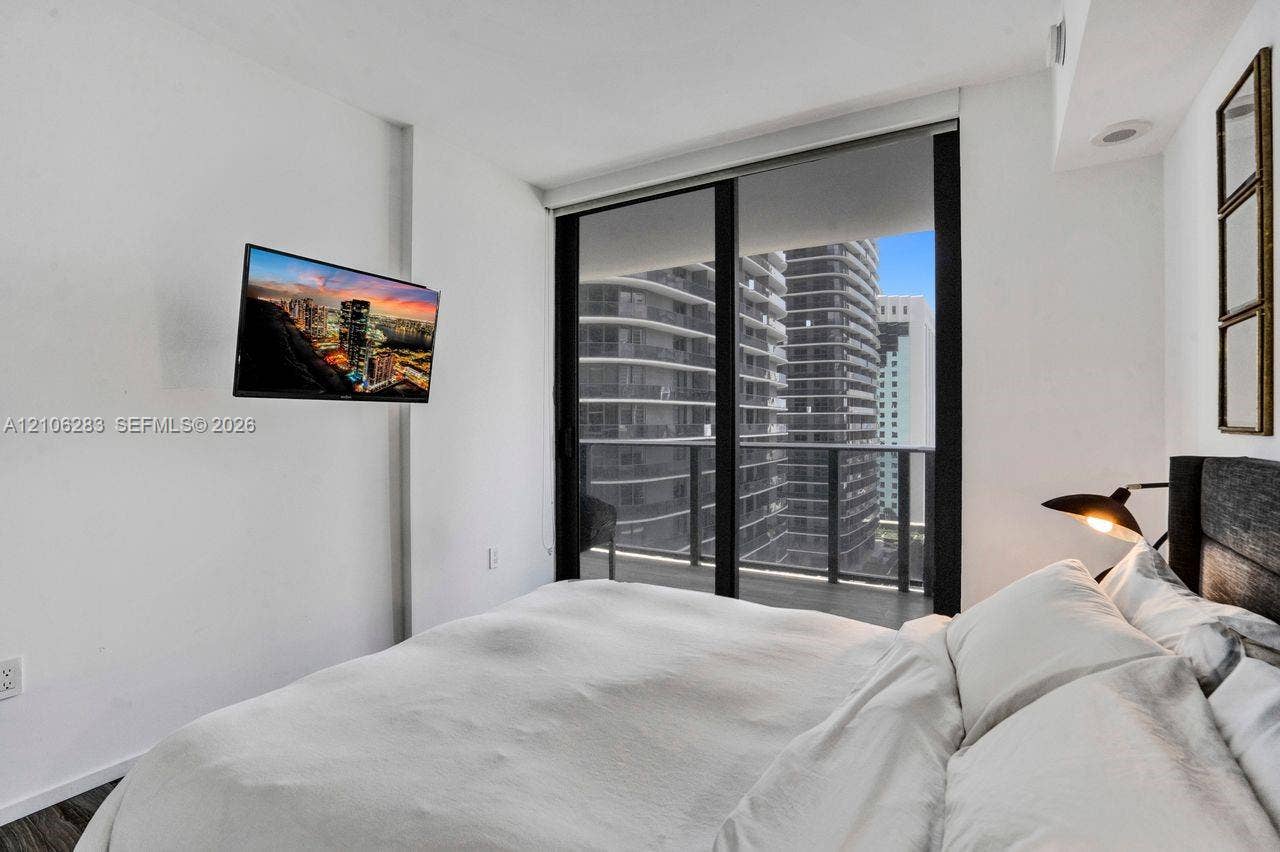 801 S Miami Avenue, #1801, Miami, FL 33130 Floor-to-ceiling sliding glass door, private balcony, wood-finish flooring, and recessed ceiling lighting