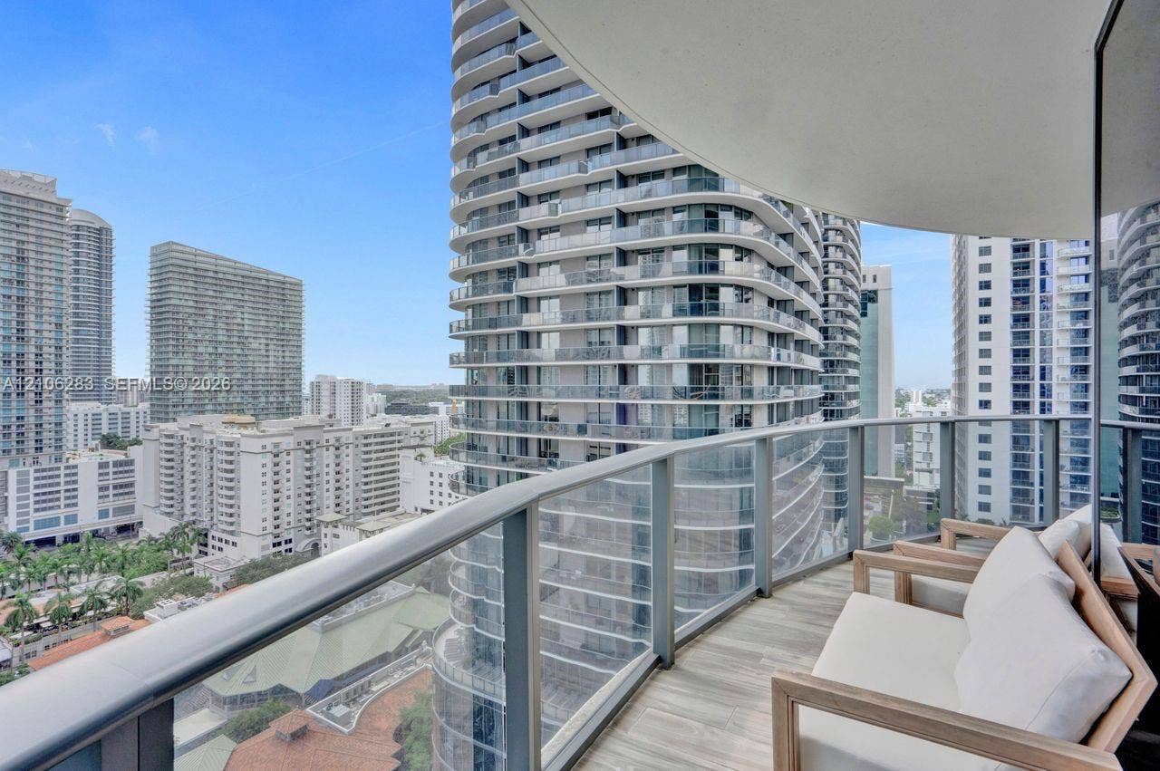 801 S Miami Avenue, #1801, Miami, FL 33130 Private balcony with a curved design, glass-paneled railing, and wood-finish flooring