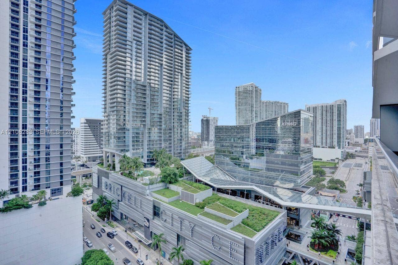 801 S Miami Avenue, #1801, Miami, FL 33130 Elevated balcony featuring a glass panel railing, showcasing an expansive cityscape, high-rise architectural surroundings, and integrated green roof structures