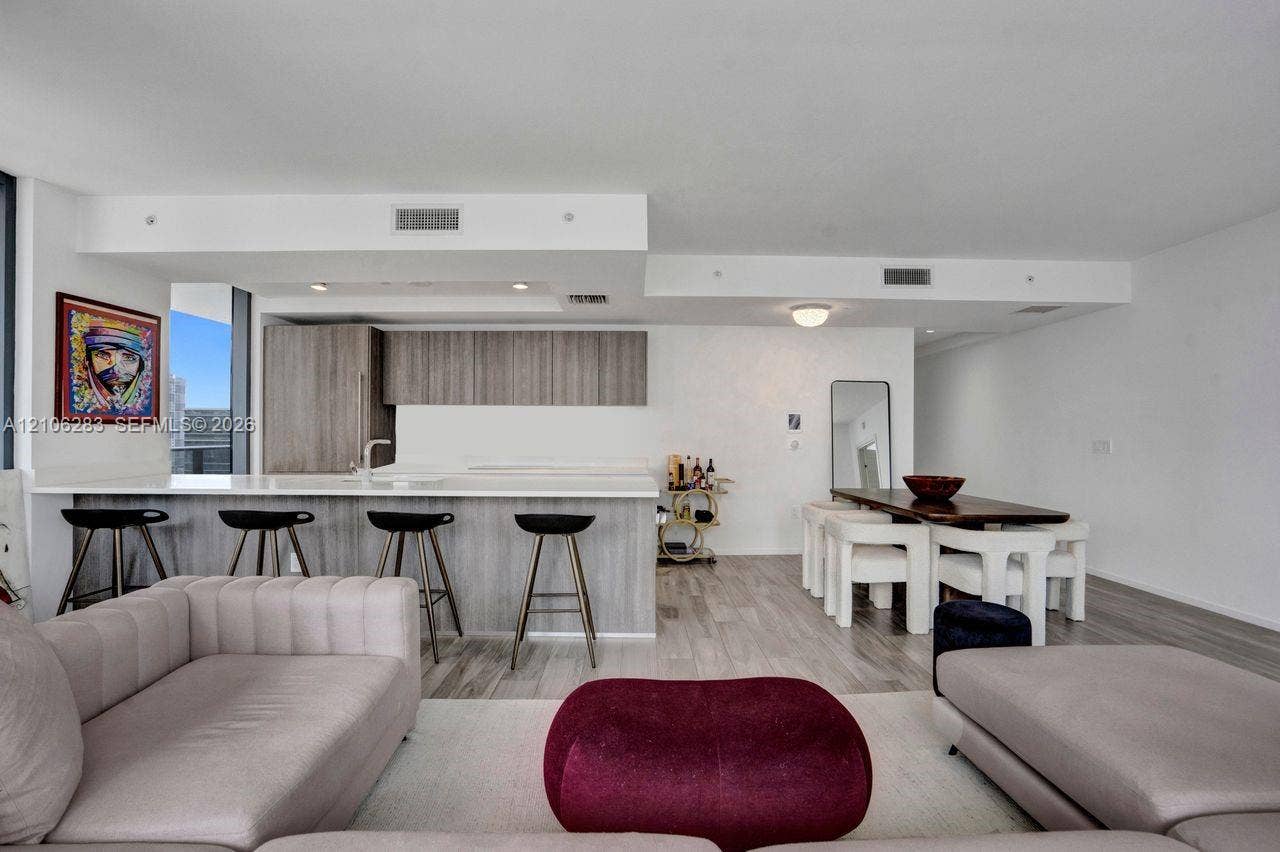 801 S Miami Avenue, #1801, Miami, FL 33130 Open-concept living space featuring wood-finish flooring, a kitchen island with stone countertop, and contemporary flat-panel cabinetry