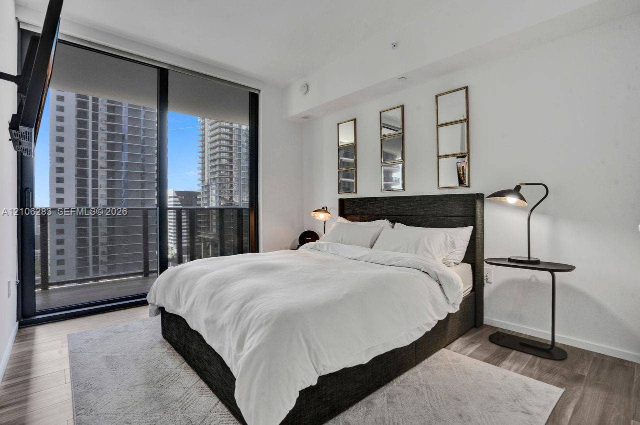 801 S Miami Avenue, #1801, Miami, FL 33130 Floor-to-ceiling glass sliding door, integrated private balcony, wood-finish flooring, and neutral wall palette