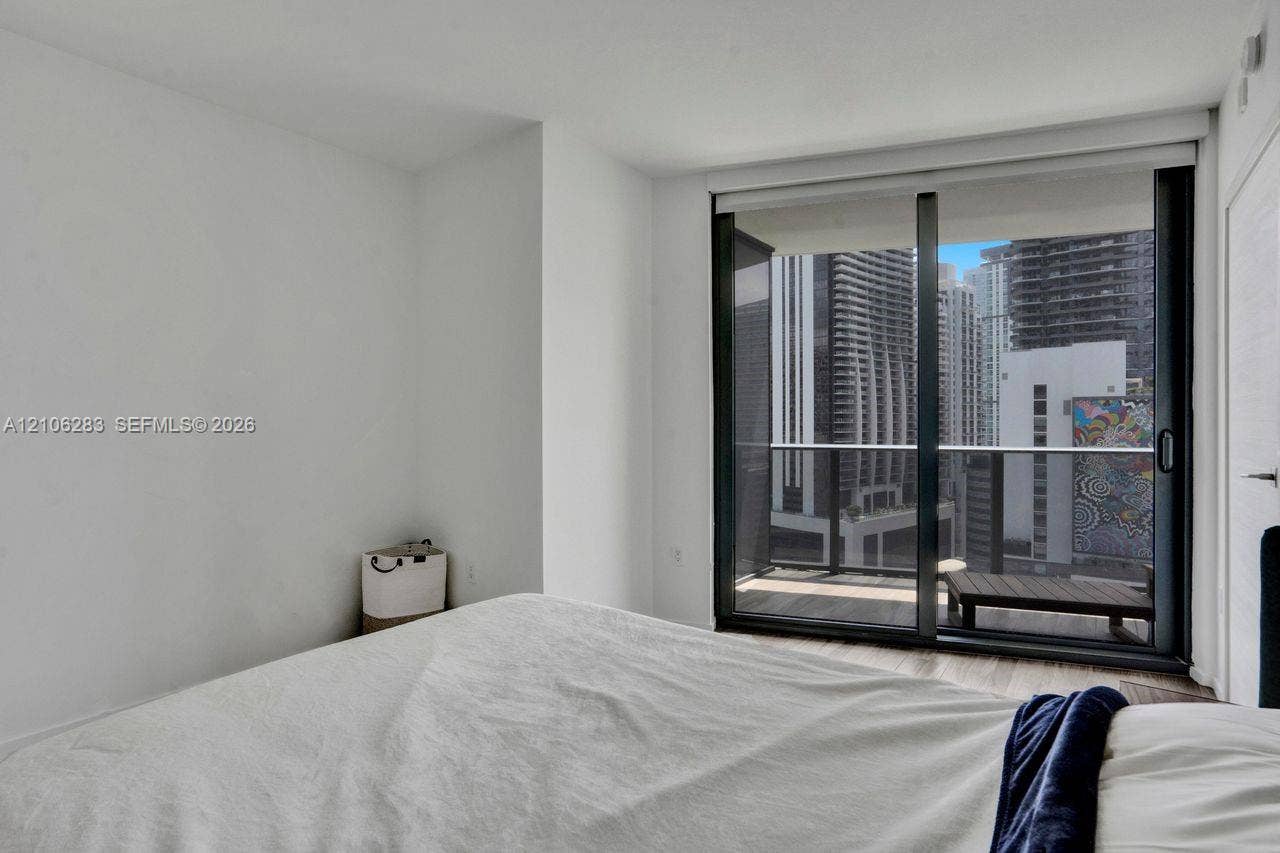 801 S Miami Avenue, #1801, Miami, FL 33130 Floor-to-ceiling sliding glass door, private balcony with metal railing, and wood-finish flooring