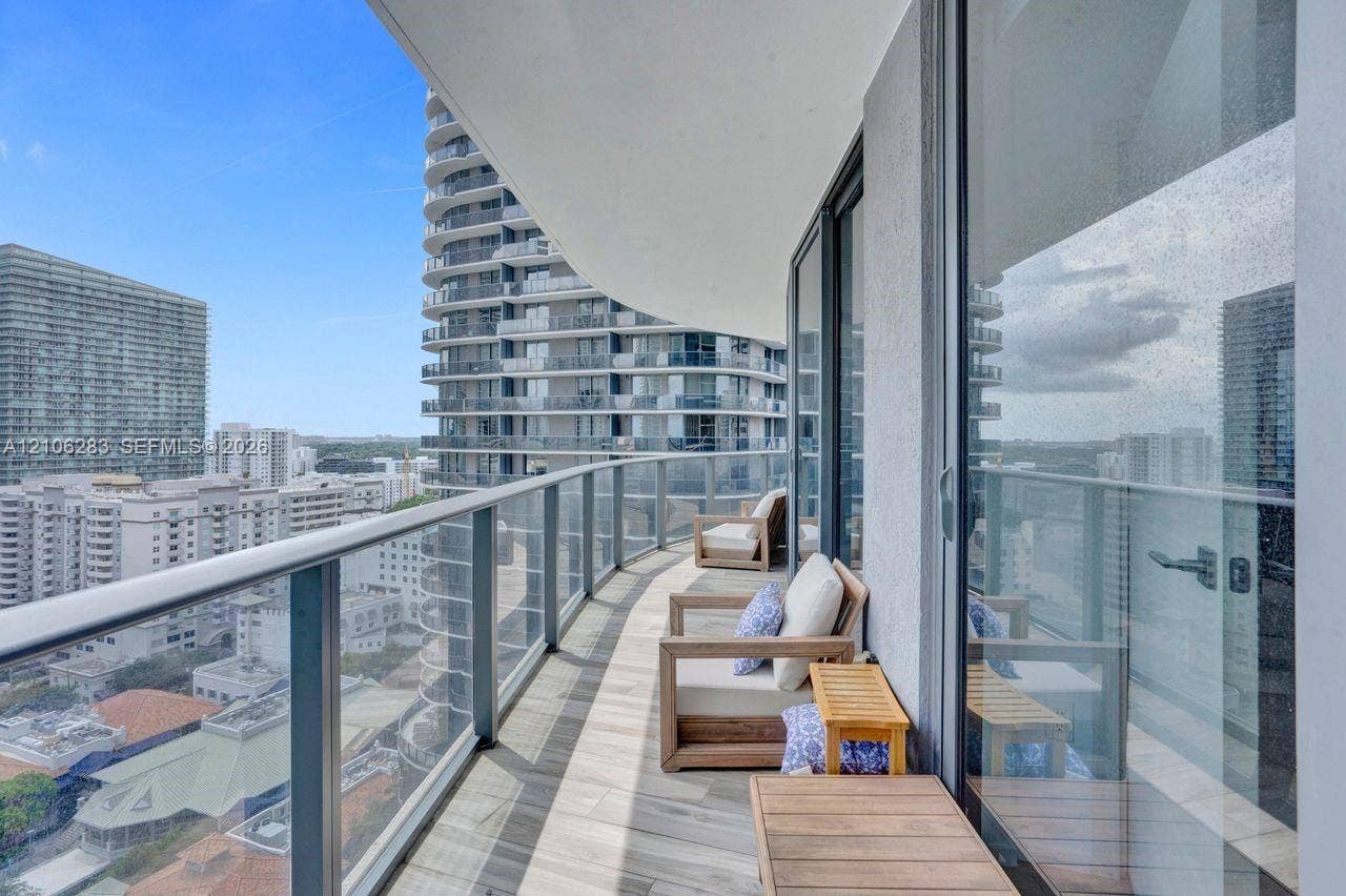 801 S Miami Avenue, #1801, Miami, FL 33130 Covered balcony featuring wood-finish flooring, glass panel railings, and full-height sliding glass doors