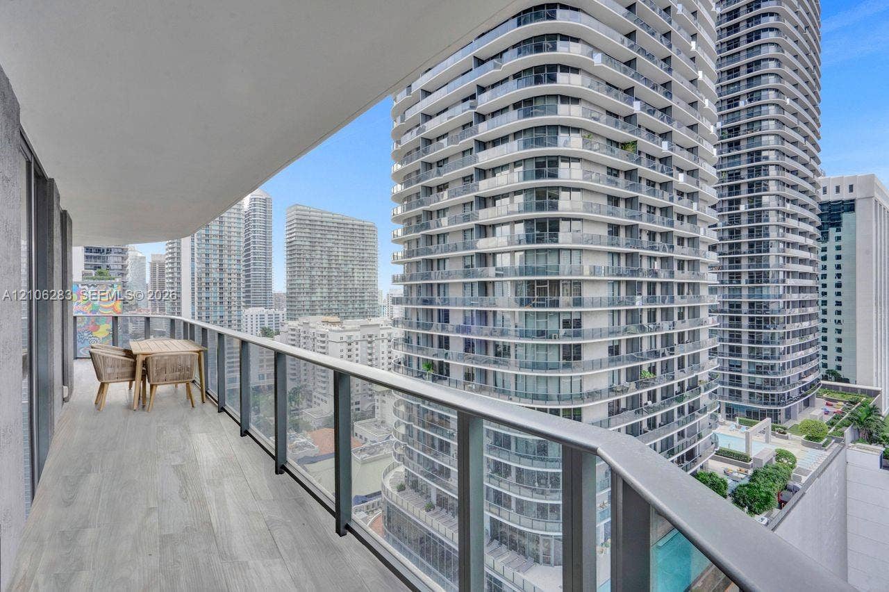 801 S Miami Avenue, #1801, Miami, FL 33130 Covered balcony featuring wood-finish flooring and a glass-paneled railing with a metal handrail