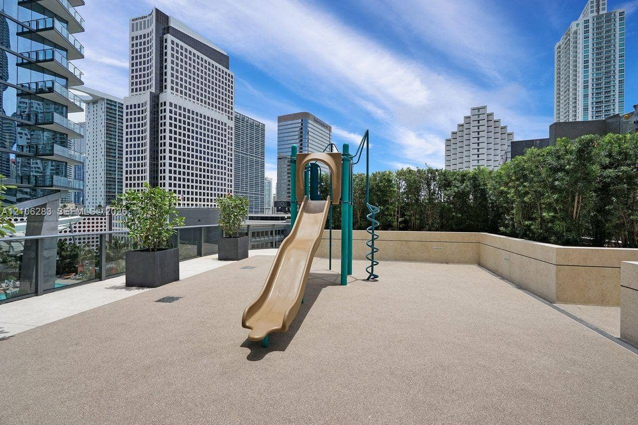 801 S Miami Avenue, #1801, Miami, FL 33130 Outdoor terrace featuring a built-in playground slide, stone-finish flooring, masonry perimeter walls, and large container planters