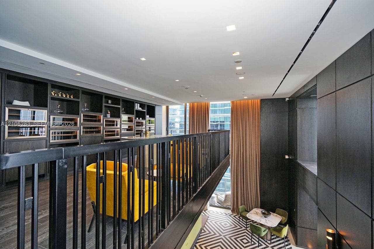 801 S Miami Avenue, #1801, Miami, FL 33130 Custom built-in cabinetry featuring integrated temperature-controlled storage, dark wood-finish wall paneling, metal railing, and recessed ceiling lighting