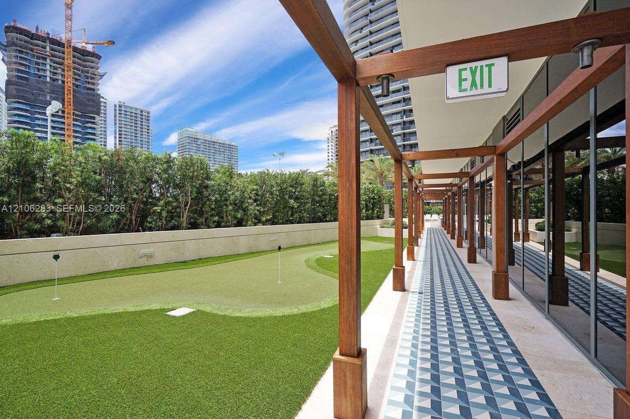 801 S Miami Avenue, #1801, Miami, FL 33130 Outdoor putting green featuring artificial turf, bordered by a wood-framed pergola and patterned tile walkway with glass wall finishes