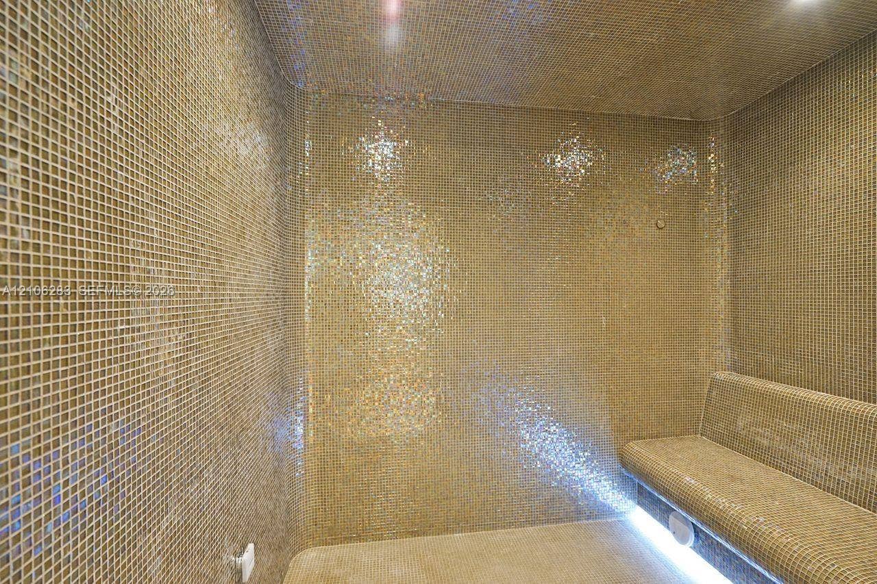 801 S Miami Avenue, #1801, Miami, FL 33130 Enclosed steam room featuring floor-to-ceiling metallic mosaic tile, built-in tiled bench, and integrated LED accent lighting