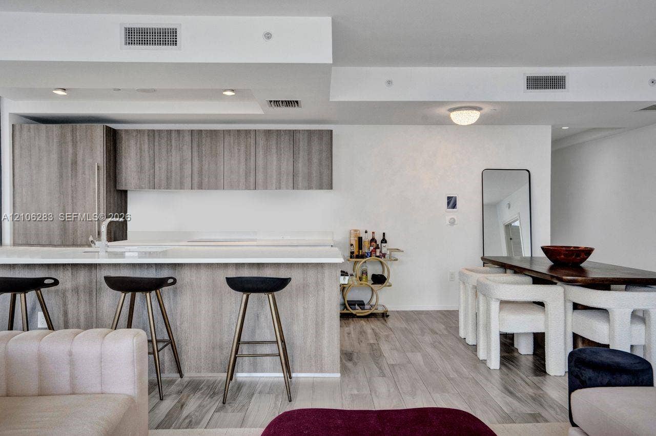 801 S Miami Avenue, #1801, Miami, FL 33130 Kitchen featuring wood-finish cabinetry, a white countertop island, integrated lighting, and wood-finish flooring