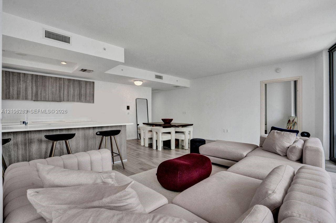 801 S Miami Avenue, #1801, Miami, FL 33130 Open-concept interior featuring light wood-finish flooring, recessed lighting, and a kitchen equipped with flat-panel cabinetry and a solid-surface breakfast bar