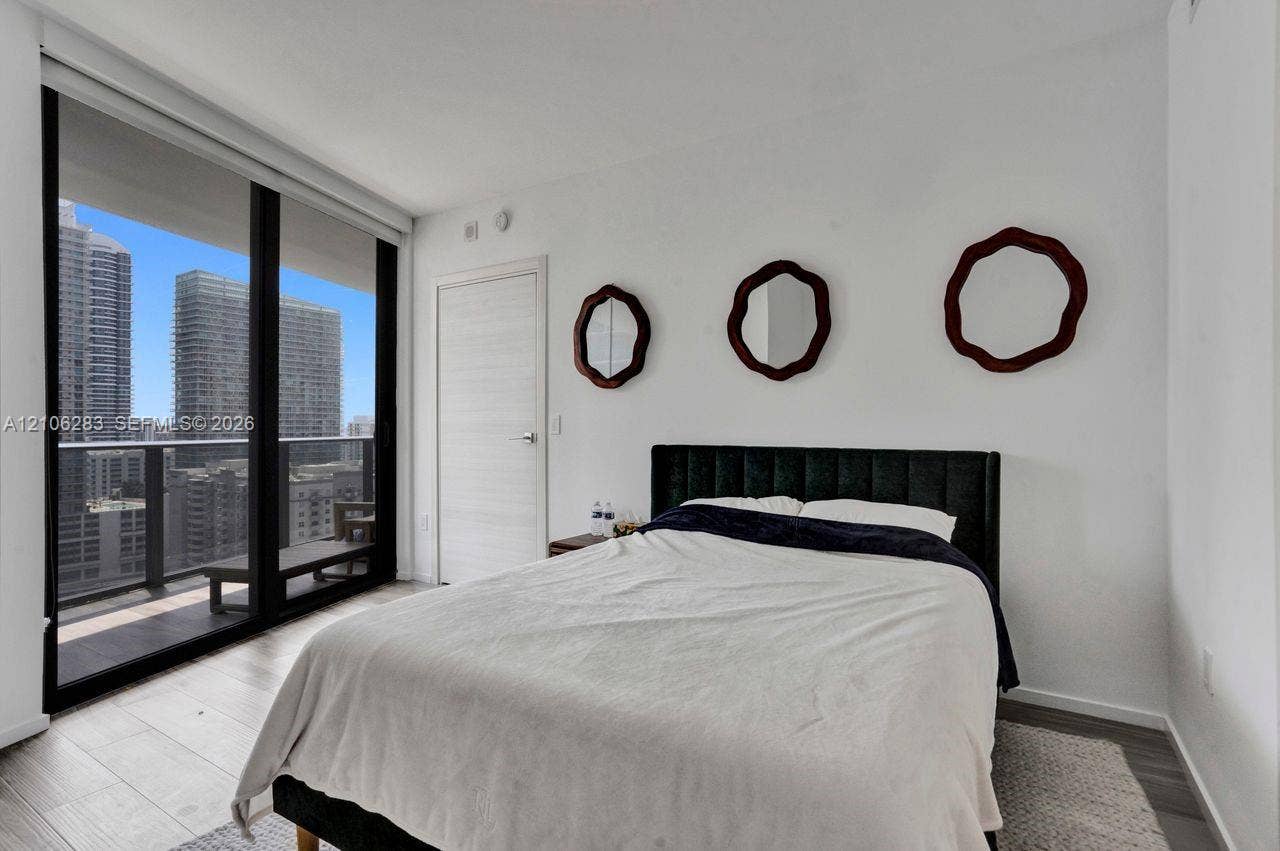 801 S Miami Avenue, #1801, Miami, FL 33130 Floor-to-ceiling sliding glass door, private balcony, wood-finish flooring, and crisp white wall finishes