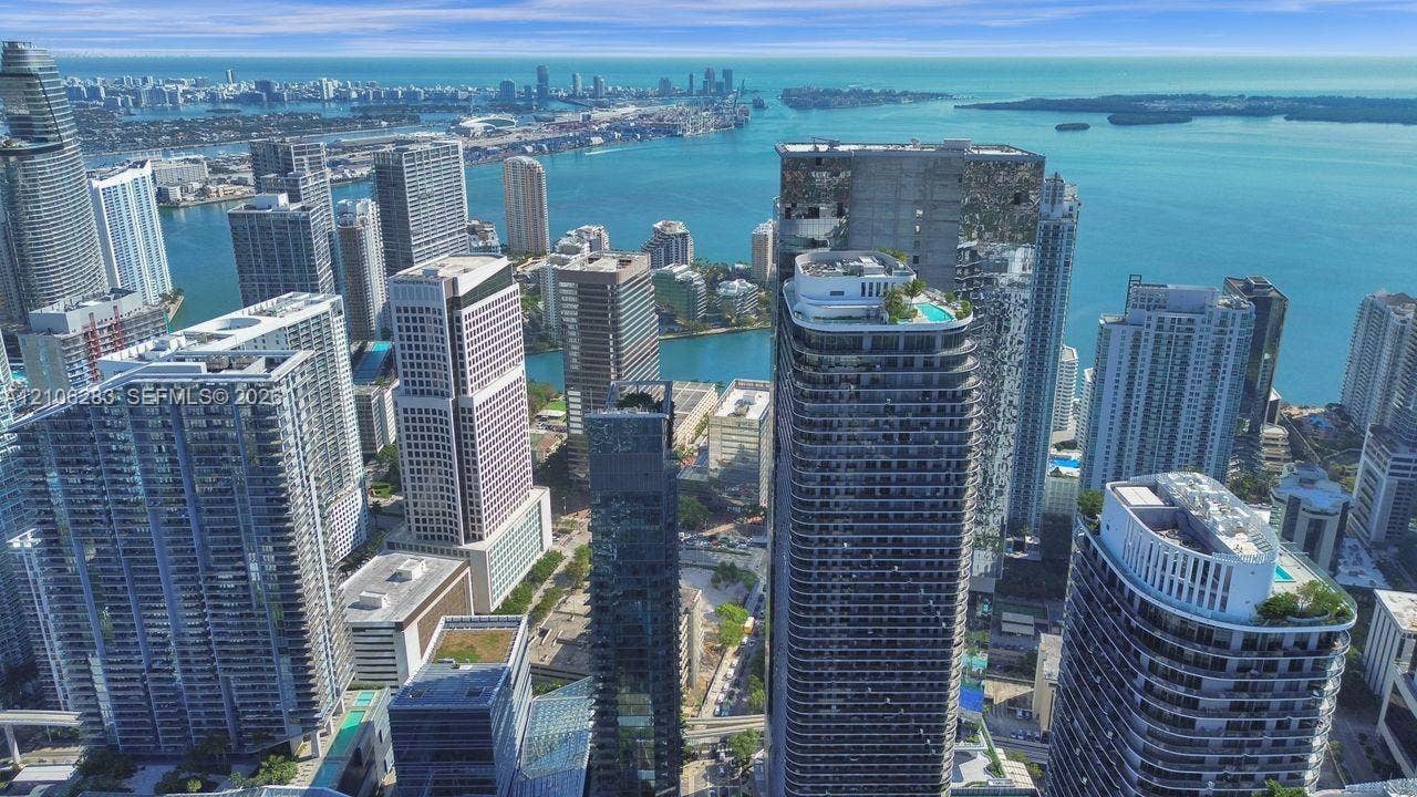 801 S Miami Avenue, #1801, Miami, FL 33130 Aerial perspective of a high-rise urban landscape featuring extensive waterfront exposure, dense architectural clusters, and rooftop recreation areas