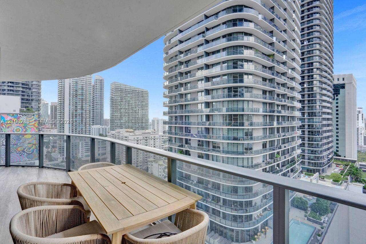 801 S Miami Avenue, #1801, Miami, FL 33130 Curved balcony featuring wood-finish flooring and metal railings, overlooking an urban skyline