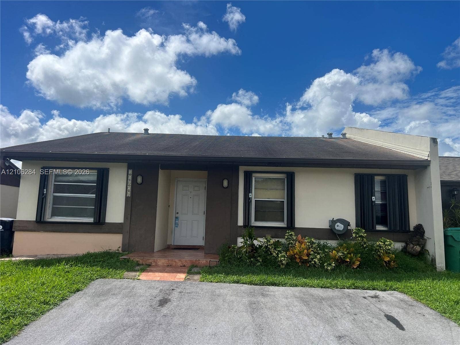 11824 SW 123rd Avenue, #., Miami, Miami, FL 33186 Single-story exterior featuring a shingled roof, stucco finish, decorative shutters, and a paved driveway