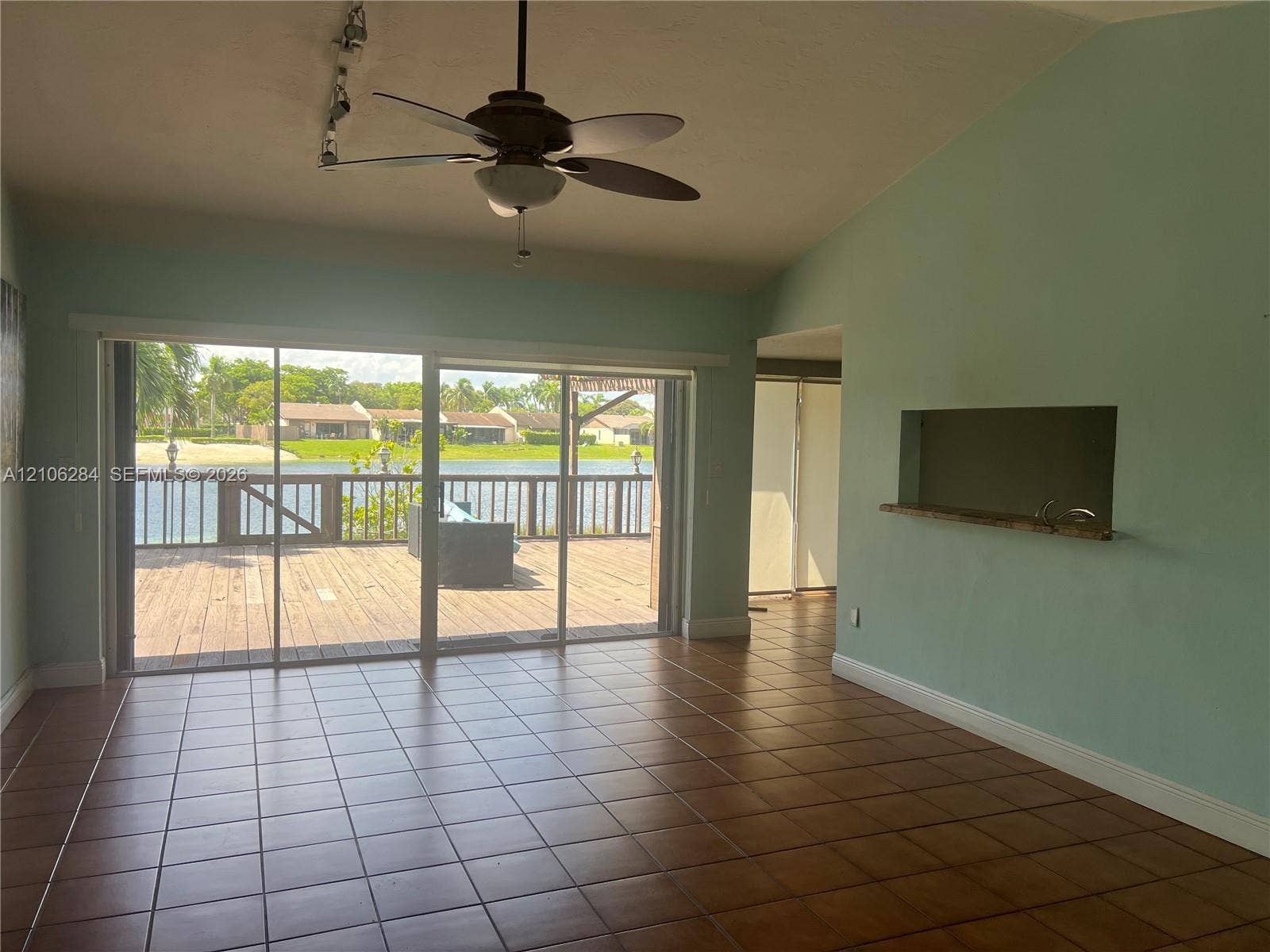 11824 SW 123rd Avenue, #., Miami, Miami, FL 33186 Ceramic tile flooring, vaulted ceilings, ceiling fan, pass-through window with shelf, and large sliding glass doors opening to a wood deck
