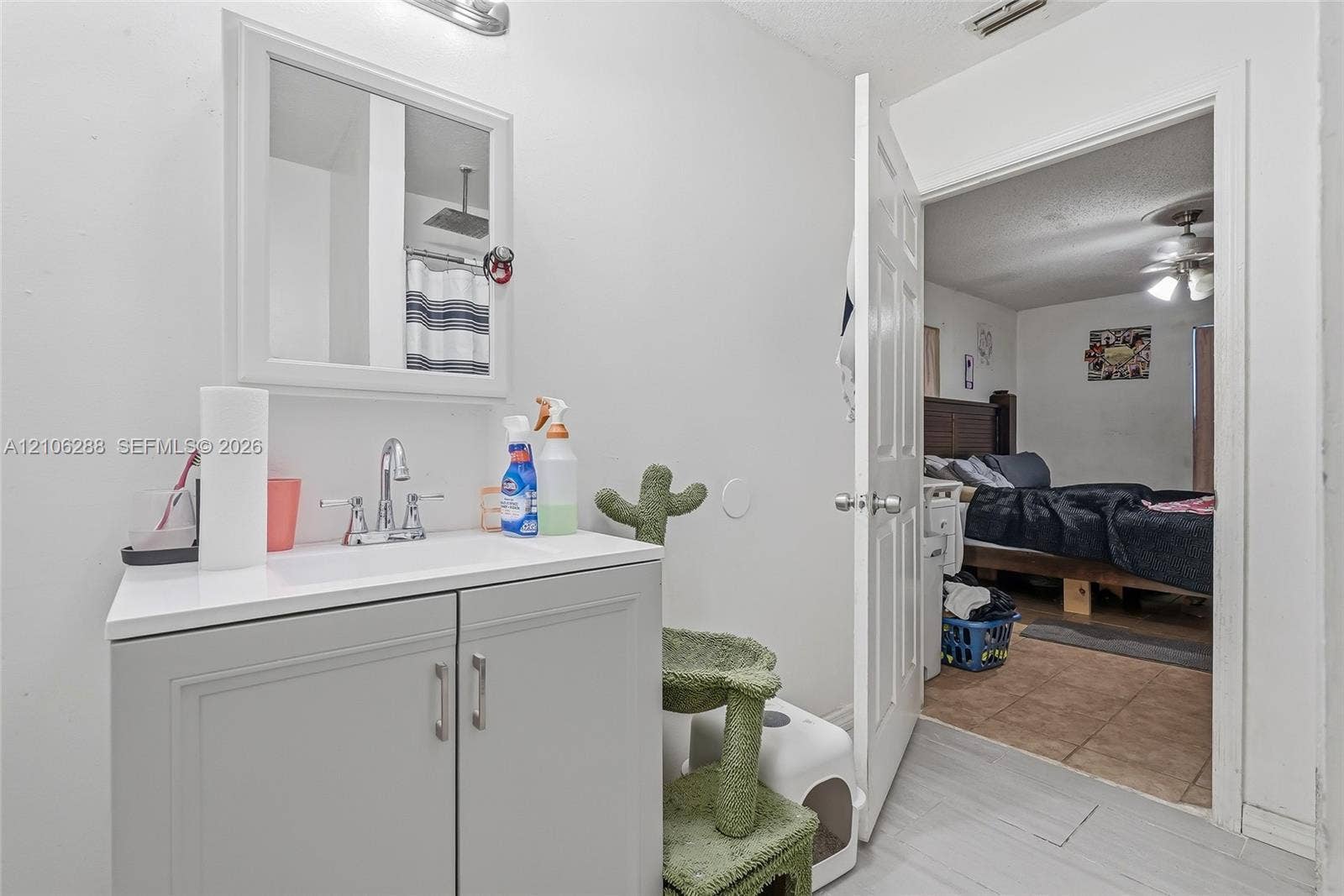 Bathroom featuring a grey vanity cabinet with a white countertop, polished chrome faucet, medicine cabinet with a mirrored door, and wall-mounted light fixture