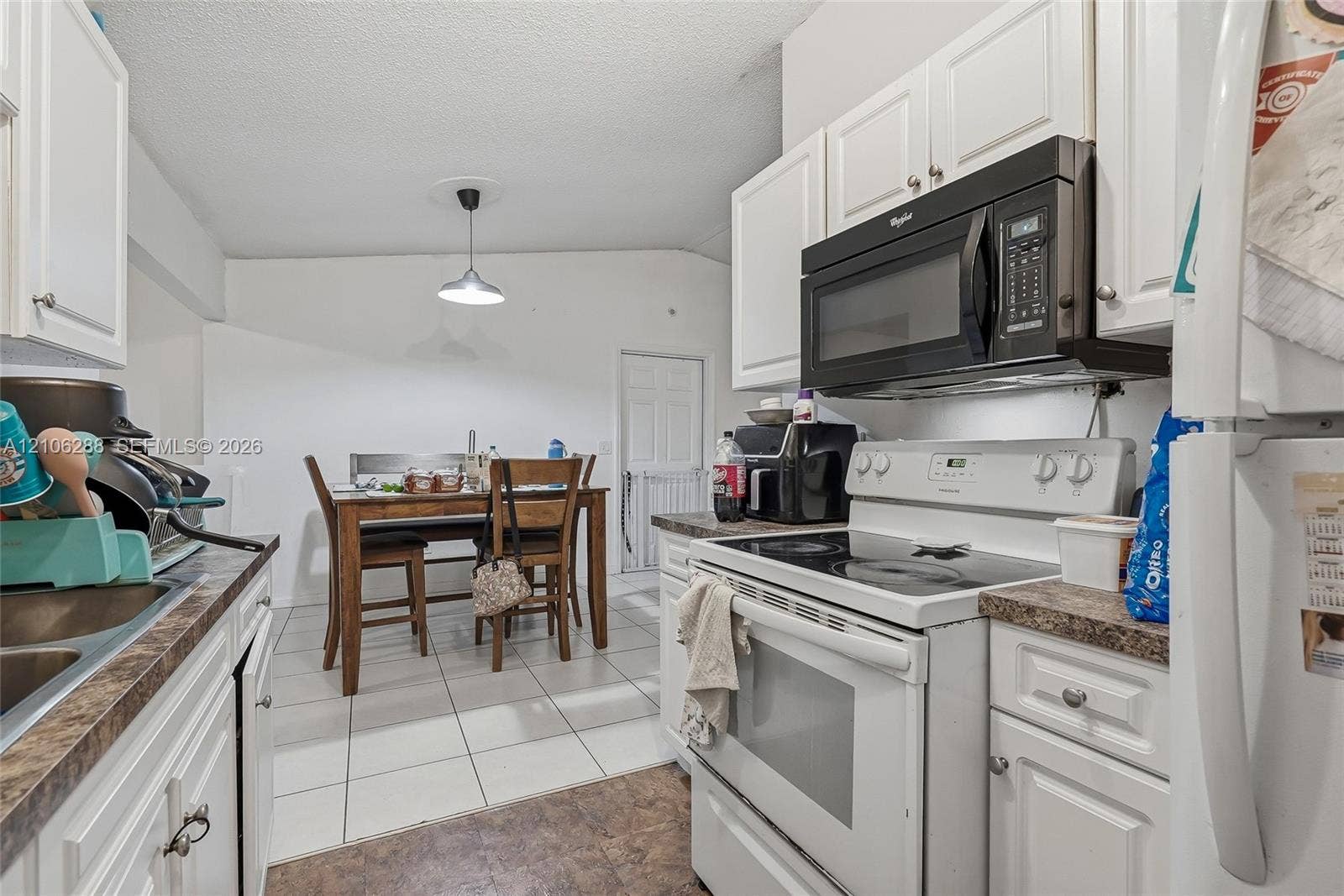 Kitchen featuring white cabinetry, stone-finish countertops, stainless steel electric range, over-the-range microwave, and tile flooring