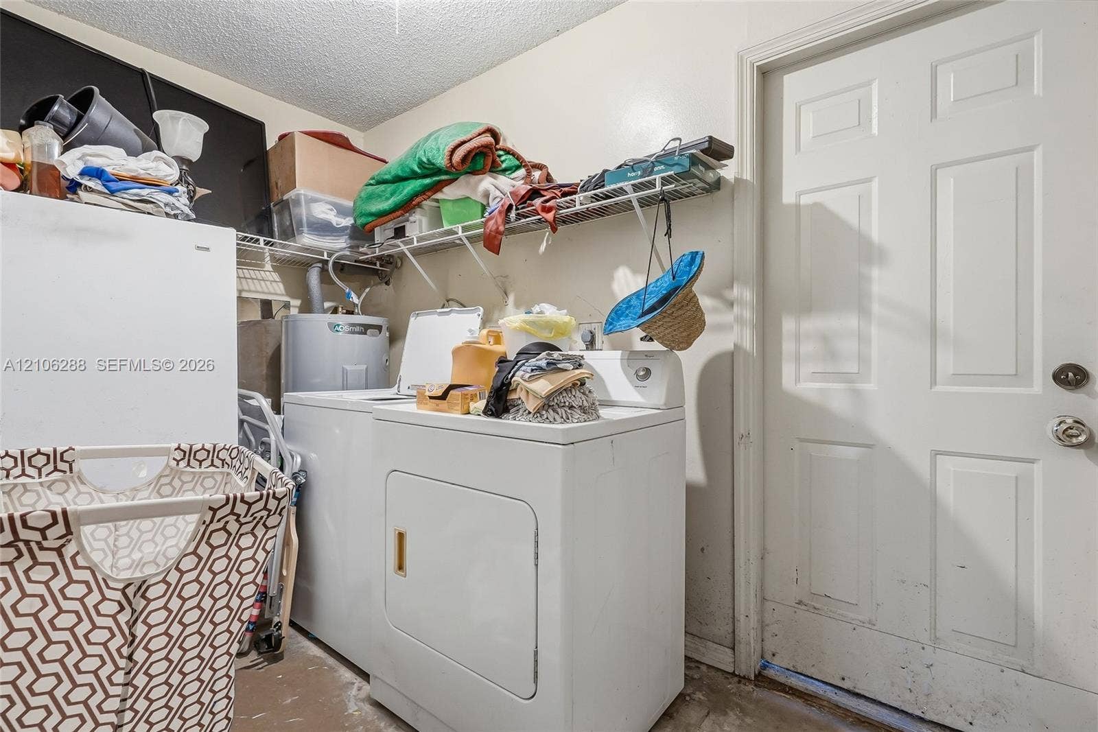 Dedicated utility space featuring a white six-panel door, metal wire shelving, and a water heater