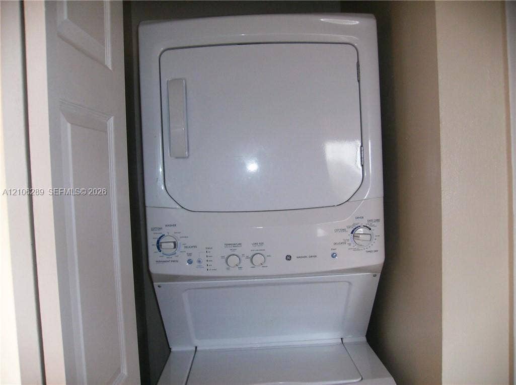White stackable washer and dryer unit with rotary controls and top-loading basin